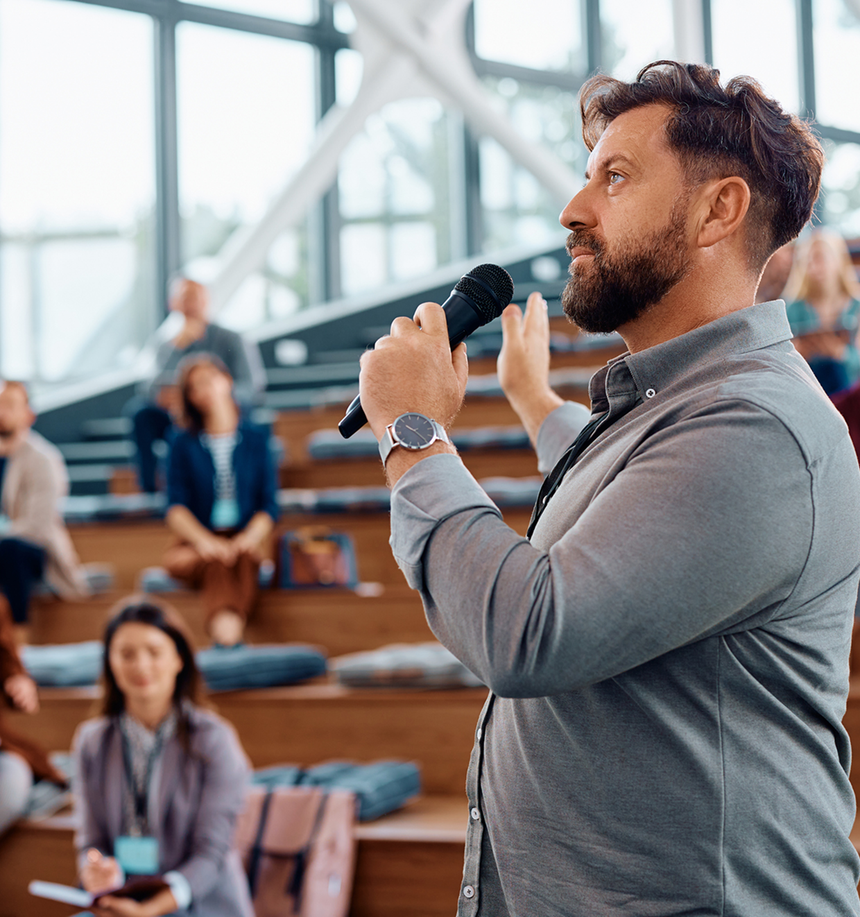 Man speaking into microphone at seminar.
