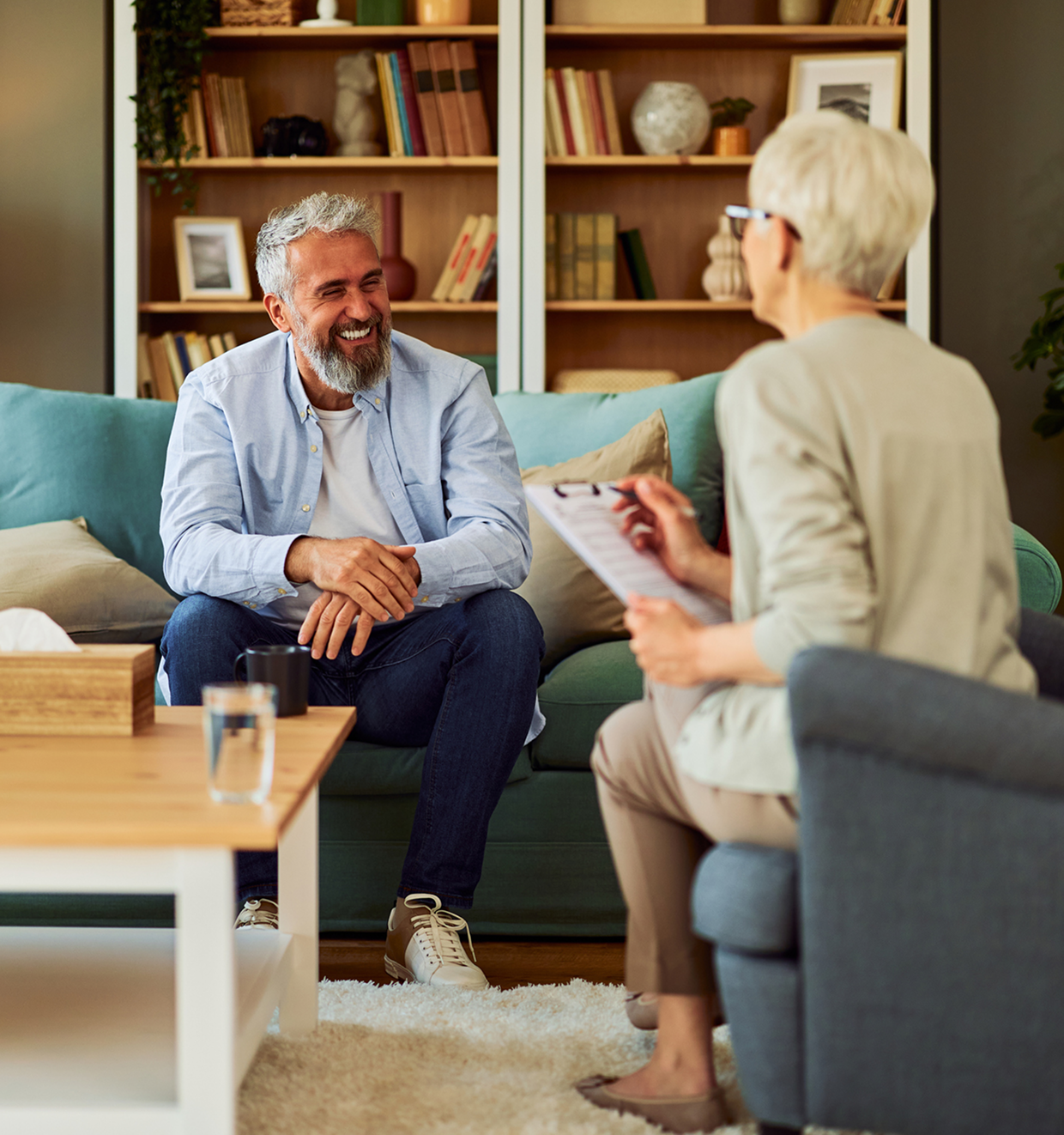 Two people talking in a cozy room.