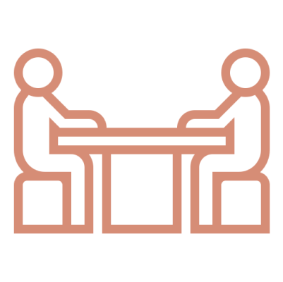 Two stick figures sitting at table.
