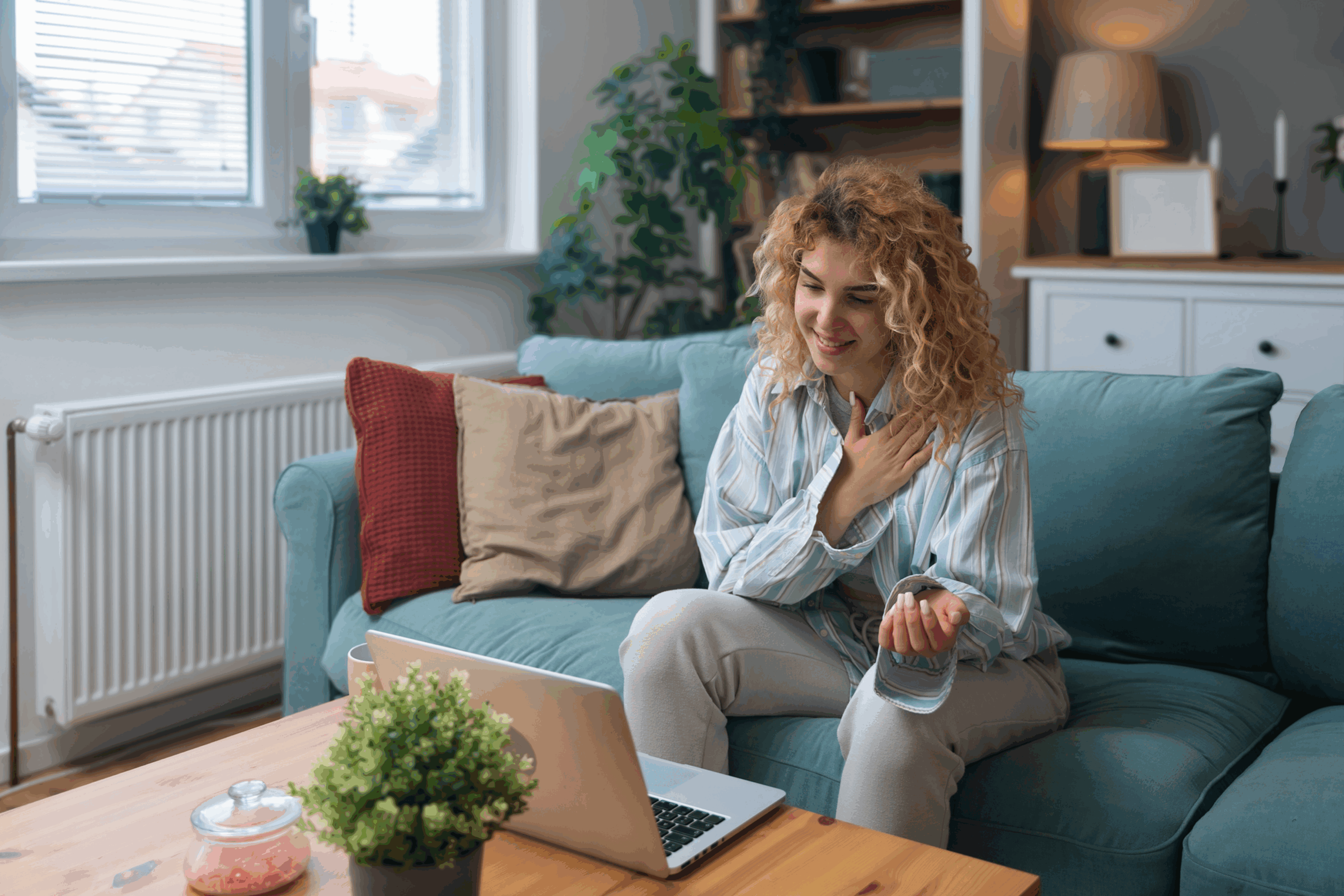 Woman video chatting on a laptop, smiling.